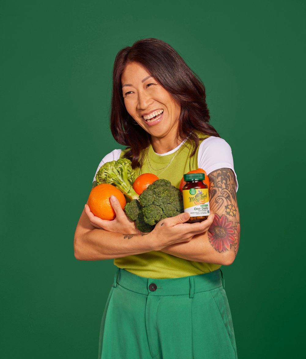 Woman holding fruits, vegetables, and vitamins